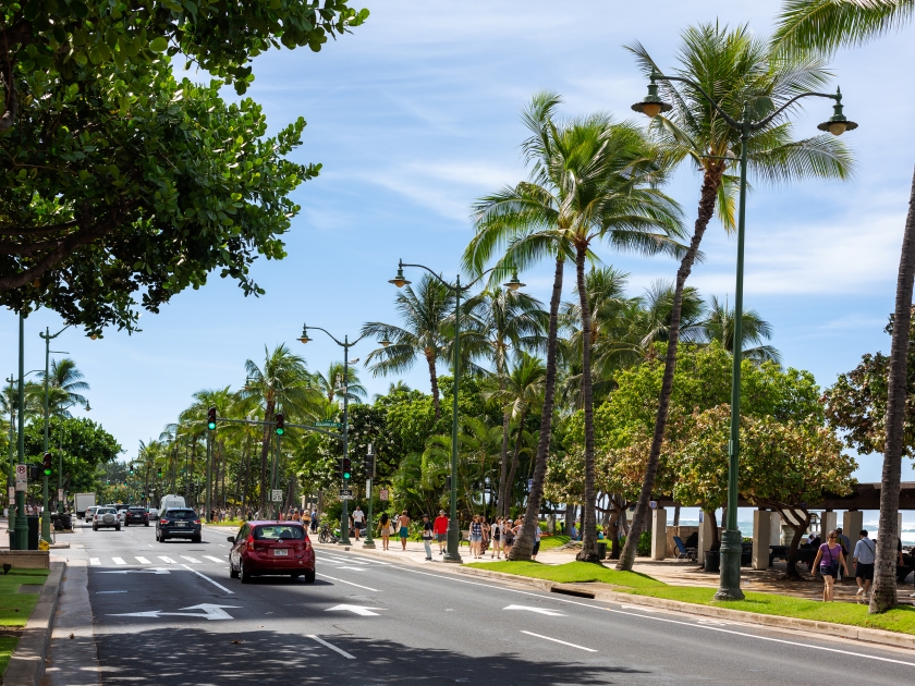 The beautiful Kalakaua Avenue lined with palm coconut trees and the beach in Waikiki Beach Honolulu Hawaii on the 5th of October 2018