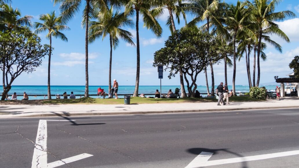 Kalakaua Avenue along Waikiki beach in Honolulu, Hawaii. Waikiki beach is neighborhood of Honolulu, best known for white sand and surfing.