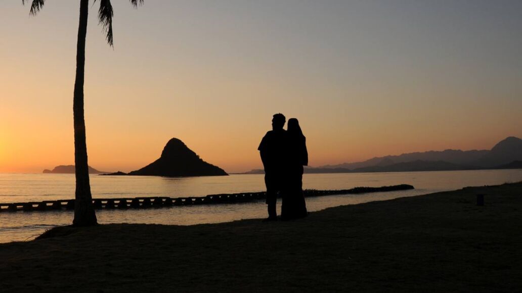 A Couple Enjoying A Chinaman's Hat Sunrise, Oahu, Hawaii