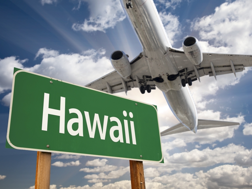 Hawaii Green Road Sign and Airplane Above with Dramatic Blue Sky and Clouds.