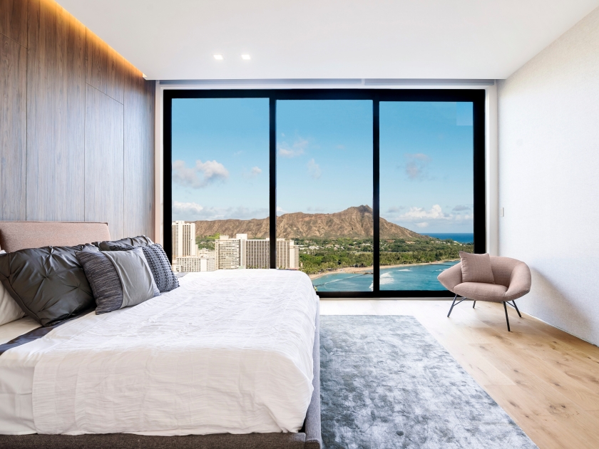 Modern and luxurious hotel bedroom with views of Waikiki beach and skyline in Honolulu, Hawaii. Condo or 5-star upscale accommodation.