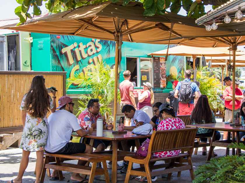 People eating outside of Tita's Grill food truck